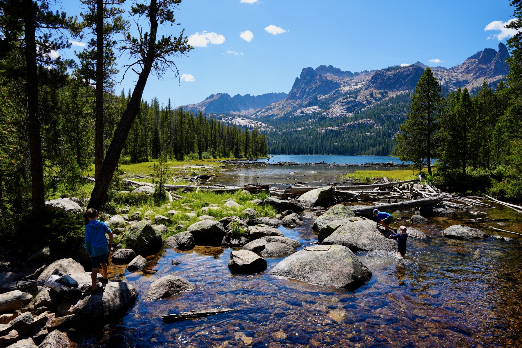 Kids playing in a mountain creek near an alpine lake